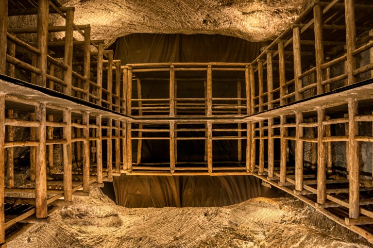 Intricate wooden scaffolding structure inside a well-lit underground cave or mine shaft.