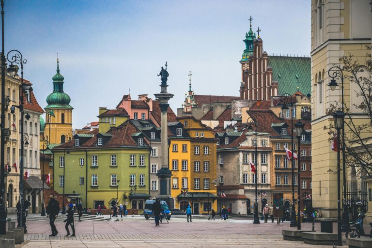 Historic square in Warsaw with colorful buildings, vibrant architecture, and lively street scene.